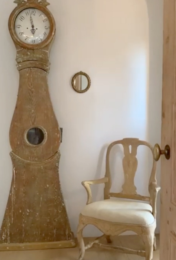 Swedish mora clock in romantic bedroom at Patina Farm (a European country farmhouse by Giannetti Home) with Old World style, sumptuous linens, a French stone fireplace, and rustic elegant charm. #moraclock #interiordesign #swedishantiques #europeancountry #frenchfarmhouse #patinafarm #brookegiannetti