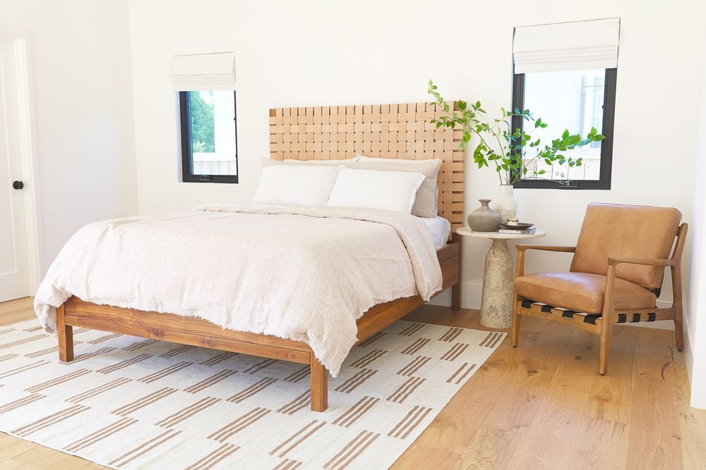 Serene white bedroom with neutrals, rustic accents, and woodsy warmth - Lulu and Georgia. #bedroomdesign #modernrustic #californiafarmhouse