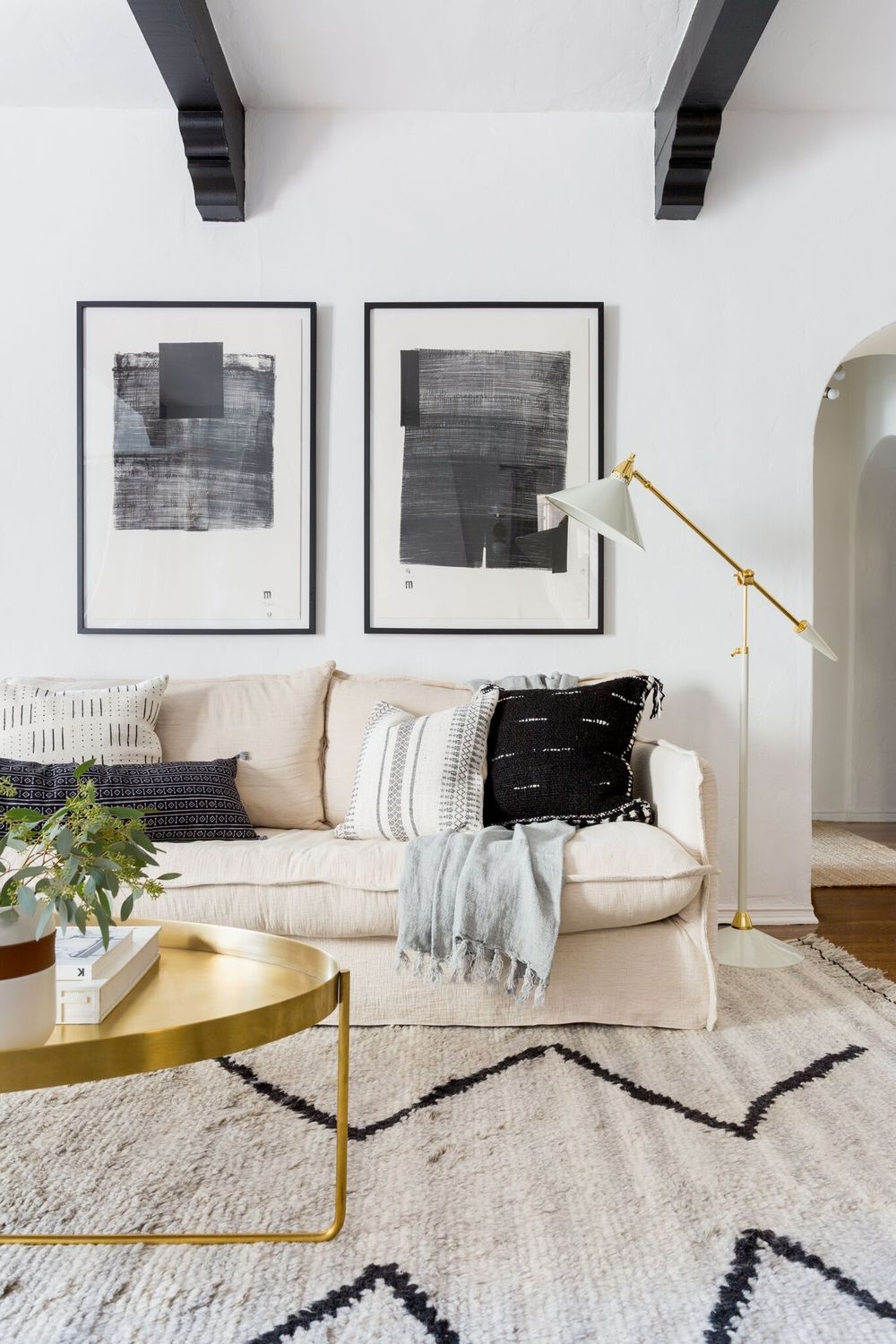 Cozy white living room with rustic accents and an airy coastal organic Cali vibe - Lulu & Georgia. #whitedecor #livingroom #casualstyle #interiordesign #neutraldecor