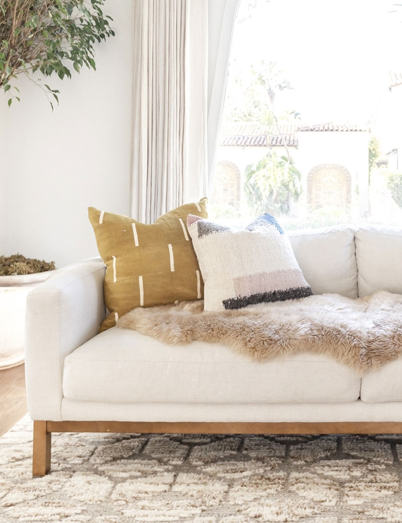 Cozy white living room with rustic accents and an airy coastal organic Cali vibe - Lulu & Georgia. #whitedecor #livingroom #casualstyle #interiordesign #neutraldecor