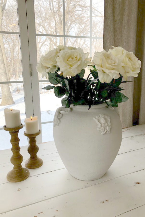 White roses in white terracotta urn on my white painted farm table in the kitchen - Hello Lovely Studio.