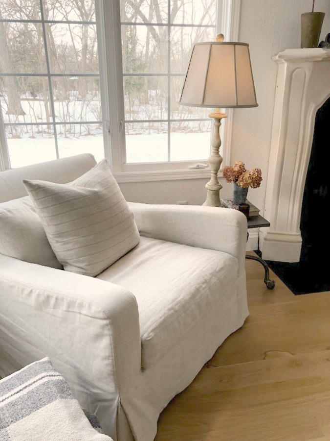 Find white living room chair ideas like this Belgian linen upholstered club chair (RH) in our living room with white oak hardwood flooring - Hello Lovely Studio. #belgianlinen #livingroom #interiordesign #neutraldecor