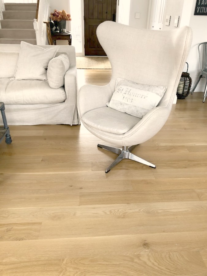 White oak hardwood flooring and Belgian linen upholstered Copenhagen egg chair (RH) in our living room - Hello Lovely Studio. #eggchair #belgianlinen #belgianstyle #livingroom #whiteoak #hardwoodfloor