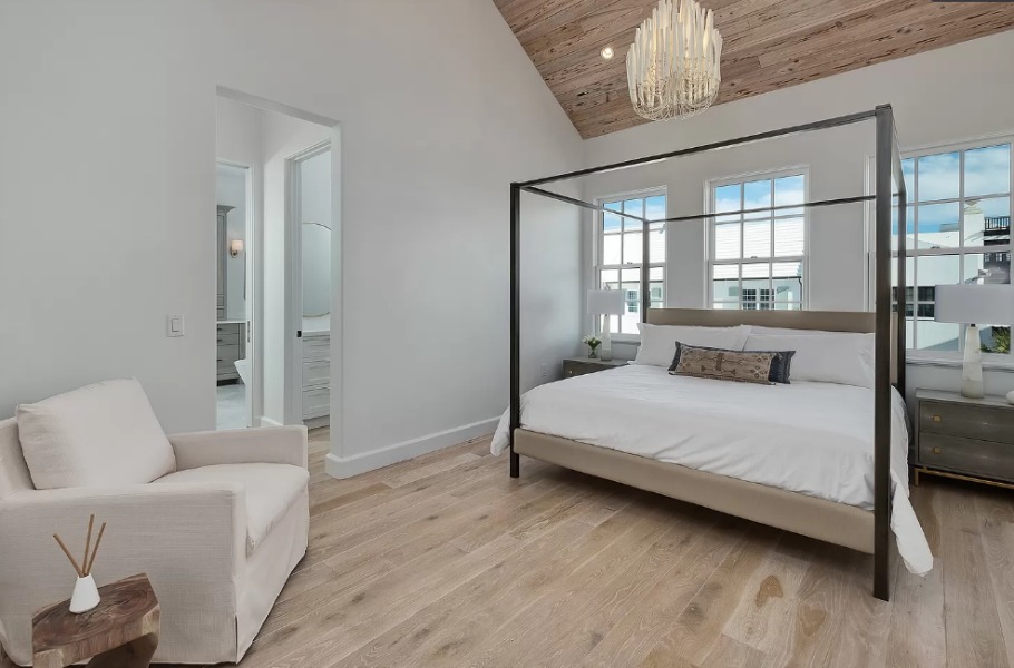 Warm minimal modern bedroom with vaulted ceiling clad in wood and light hardwood flooring - design by Domin Bock. #bedroomdecor #coastalbedroom #luxuriousbedroom #interiordesign #woodceiling