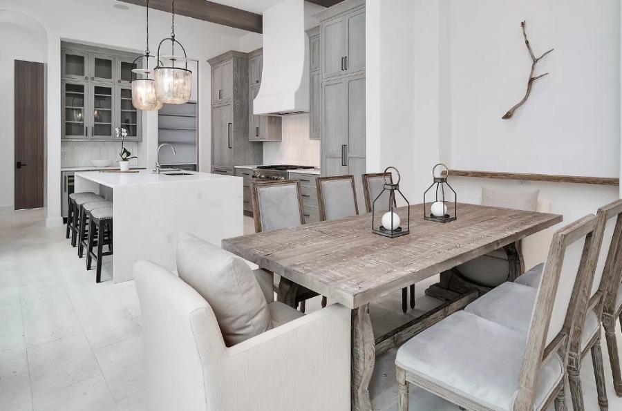 Understated, muted neutrals in a luxurious kitchen and breakfast room of a coastal home (Alys Beach) by Domin Bock. #kitchendesign #warmminimal #luxuriouskitchen #greycabinets #customkitchen