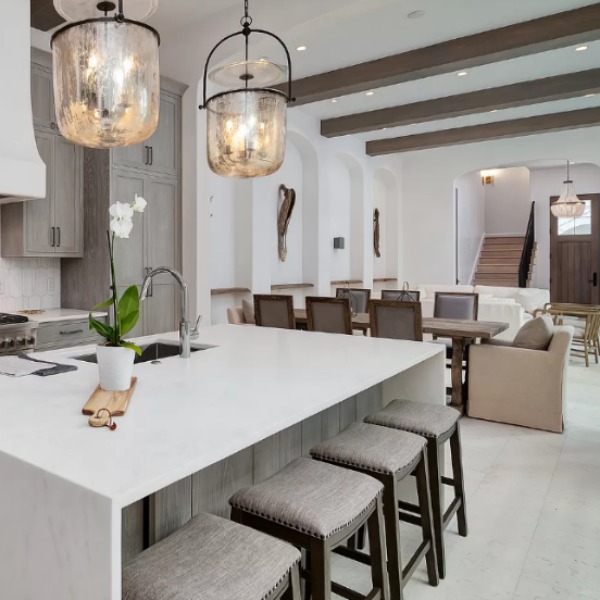 Understated, muted neutrals in a luxurious kitchen and breakfast room of a coastal home (Alys Beach) by Domin Bock. #kitchendesign #warmminimal #luxuriouskitchen #greycabinets #customkitchen