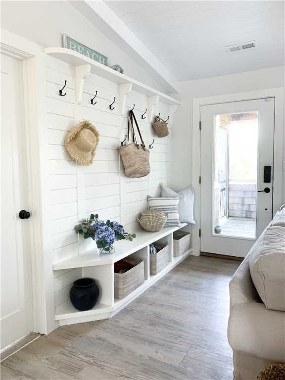 Charming entry with hooks and cubbies in a coastal cottage in NC called Summerfell. #coastalcottage #interiordesign #builtins #mudroom