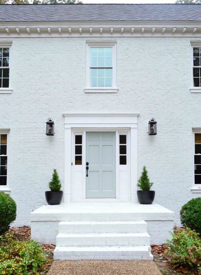 White brick house exterior with pastel front door - Young House Love. #whitebrick #houseexterior #paintedbrick #sherwinwilliamsmodernewhite #benjaminmooretranquility