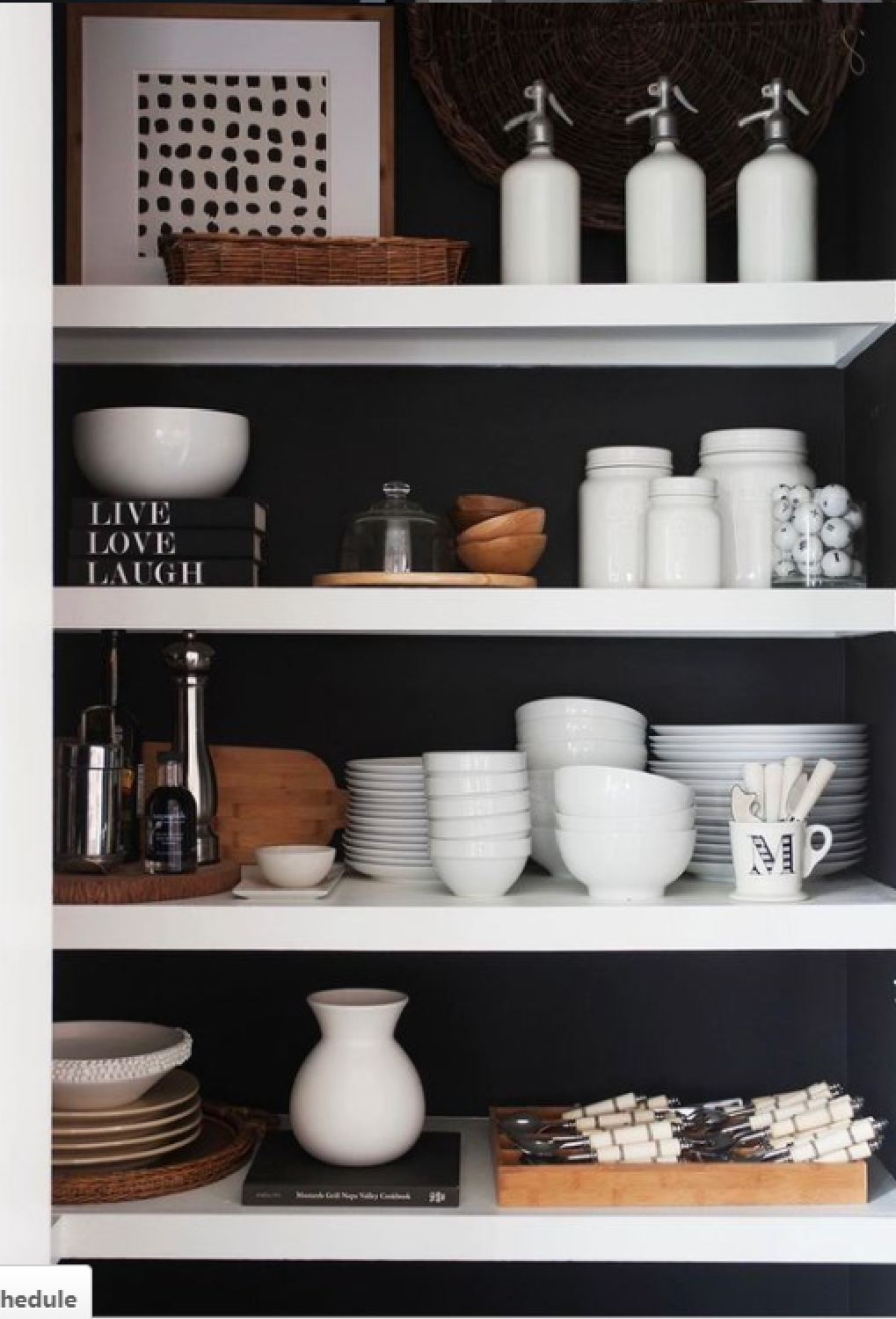 White pantry shelves contrast with black painted wall for a dramatic effect in a kitchen - design by Sherry Hart. #blackandwhite #pantry #blackwalls #interiordesign