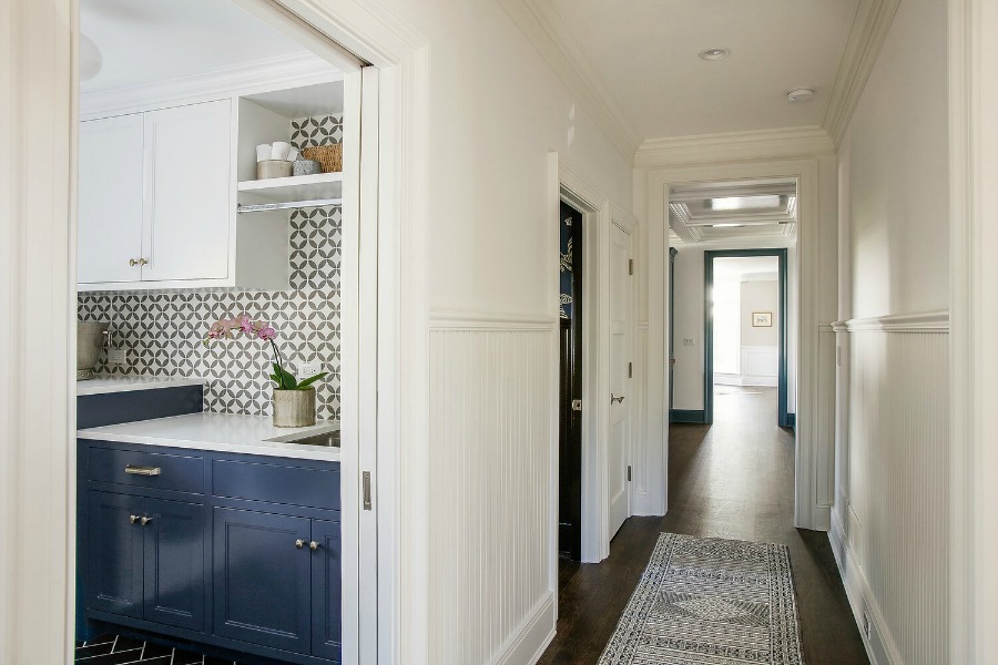 Laundry room with bold tiled walls and blue cabinets - Edward Deegan Architects. #laundryroom #blueandwhite #bluecabinets