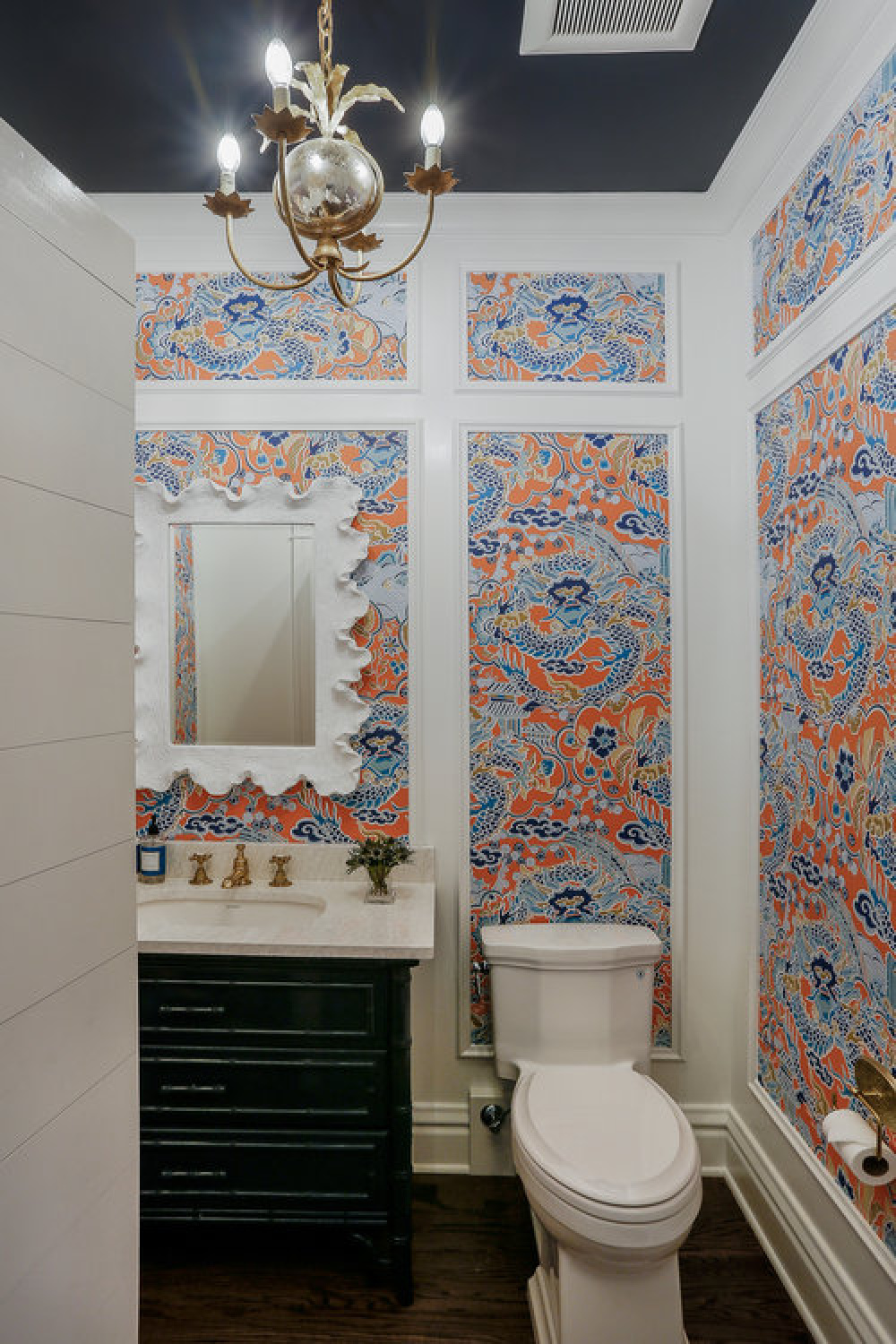 Traditional style powder bathroom design with custom millwork, wallpaper with blue accents, and design by Edward Deegan Architects.