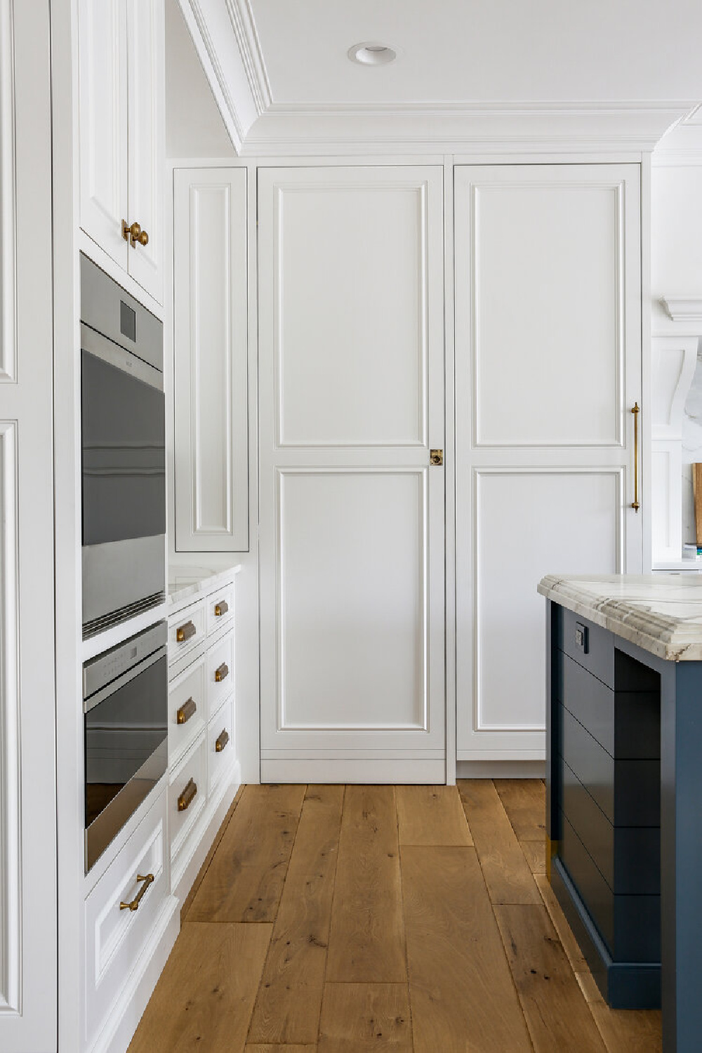 Classic white kitchen with custom cabinets, wall ovens, and blue accents - Edward Deegan Architects. Find more blue kitchen ideas in this story!