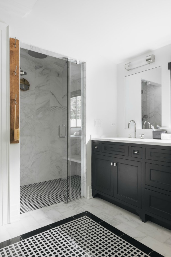 Timeless, traditional, and classic, this black and white modern farmhouse bath by Edward Deegan feels approachable yet luxurious. #modernfarmhouse #interiordesign #blackandwhite #bathroomdesign