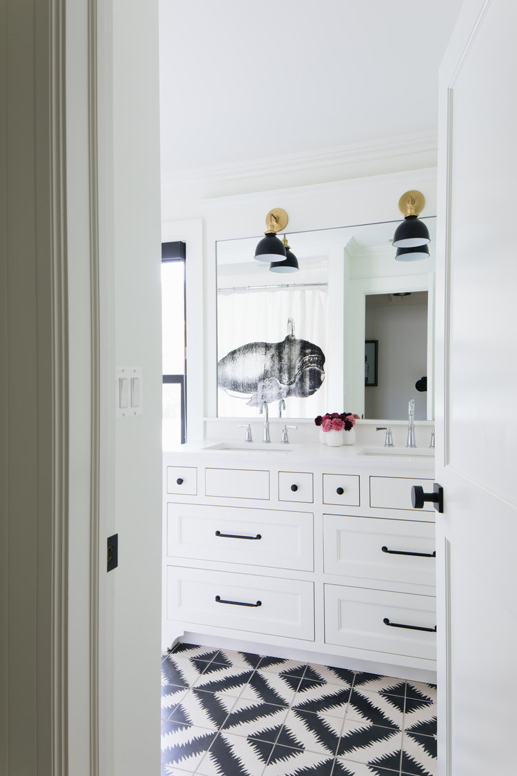 Timeless, traditional, and classic, this black and white modern farmhouse bath by Edward Deegan feels approachable yet luxurious. #modernfarmhouse #interiordesign #blackandwhite #bathroomdesign