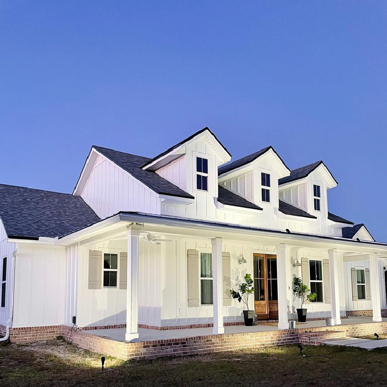 Extra White (Sherwin Williams) paint color on board and batten siding of a modern farmhouse by @thehouseonpineridg #extrawhite #paintcolors #exteriorcolors #housecolors