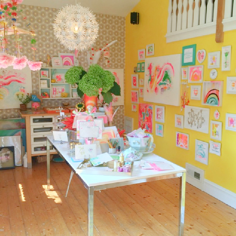 Cheerful yellow gallery wall with art in Jenny Sweeney's darling boho colorful art studio.