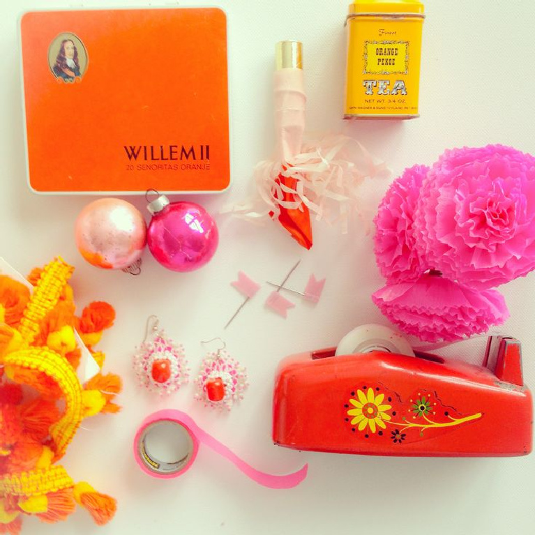 Cheerfully bold pink and orange vintage objects are gathered in a beachy 70's boho vignette by Jenny Sweeney.