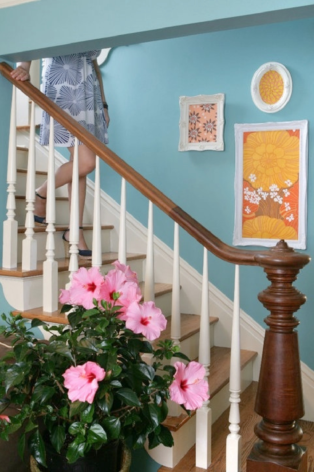 Turquoise beachy wall paired with traditional wood staircase in the beachy boho groovy living room of Jenny Sweeney.