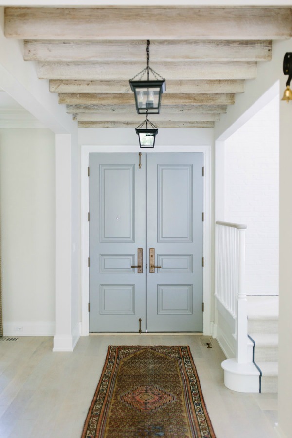 Serene entry with pale grey doors and wood rafters in a lovely home by Kate Marker in Barrington, IL. Come enjoy encouraging love quotes and timeless decor inspiration!#interiordesign #entry #greydoors #serenedecor