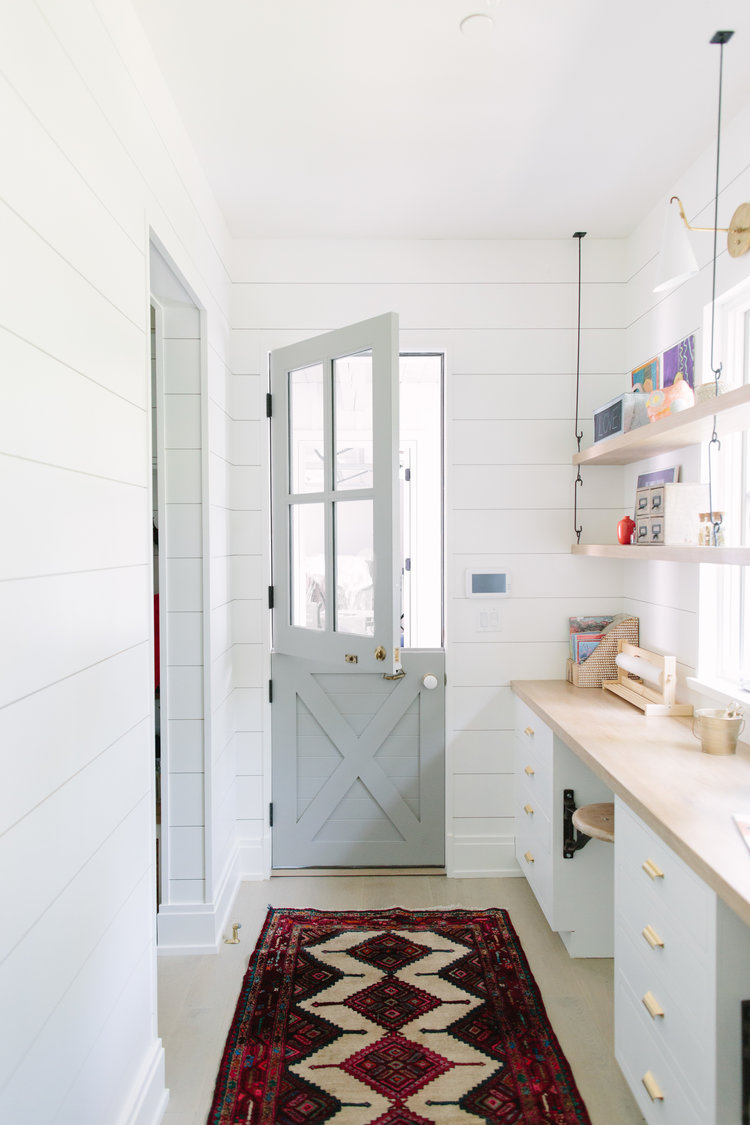 Serene and enchanting, a light grey painted Dutch door opens into a welcoming home with interior design by Kate Marker in Barrington, IL. #interiordesign #dutchdoor #serenedecor