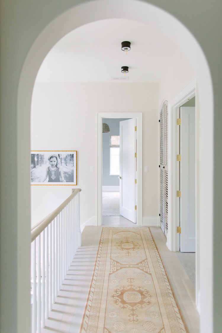 Archways and reclaimed materials come together in a beautiful hall within a home by Kate Marker in Barrington, IL. #interiordesign #archway #serenedecor