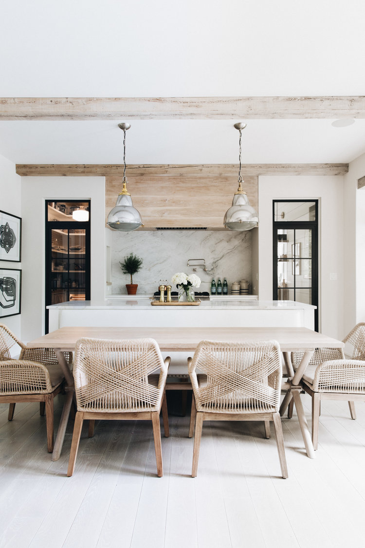 Greyed finish on wood range hood and ceiling beams, black trimmed doors, and serene decor in a kitchen by Kate Marker in Barrington, IL. #kitchendesign #modernfarmhouse #greyoak #woodbeams