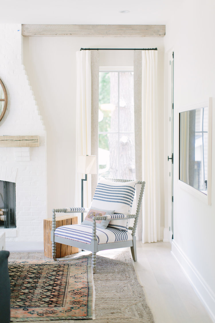 White and bright modern farmhouse living room with spindle chair and design by Kate Marker in Barrington, IL. #modernfarmhouse #livingroom #serenedecor