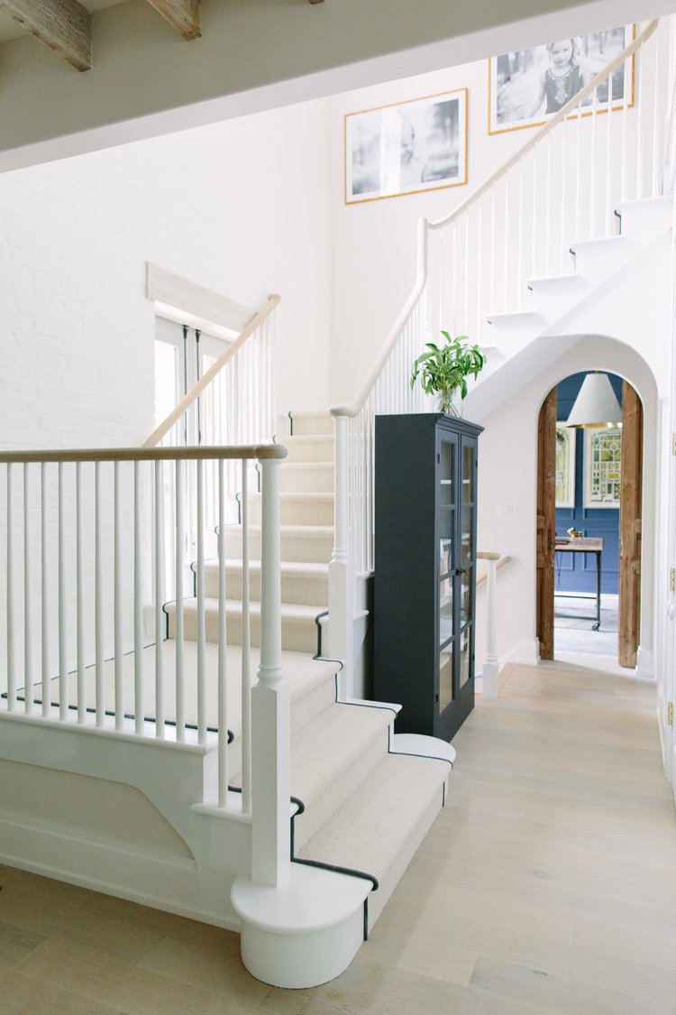 Magnificent staircase and archways in a beautiful modern farmhouse with interior design by Kate Marker in Barrington, IL. Come enjoy encouraging love quotes and timeless decor inspiration! #modernfarmhouse #staircase #interiordesign