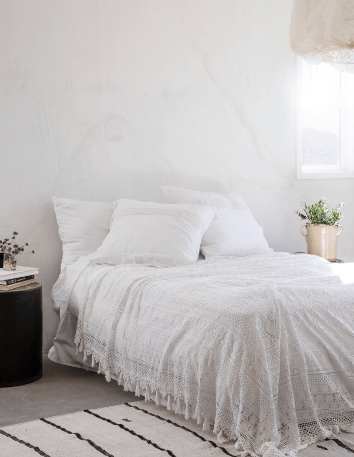 Warm minimal modern rustic luxe bedroom with white lace bedspread (Shabby Chic's Cluny) designed by Leanne Ford for HGTV's Rock the Block. #leanneford #bedroomdesign #rusticmodern #interiordesign #whitebedroom