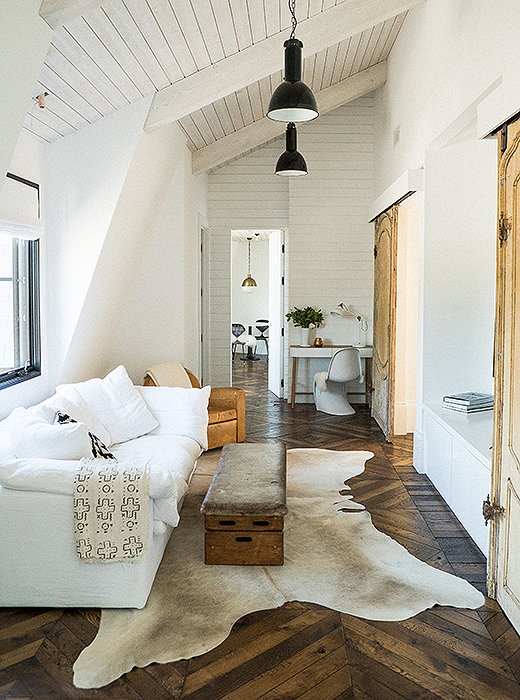 Warm minimal, modern rustic boho interior design with white sofa, cowhide, and vintage - design by Leanne Ford. #leanneford #interiordesign #roughluxe #minimaldecor #vintageboho