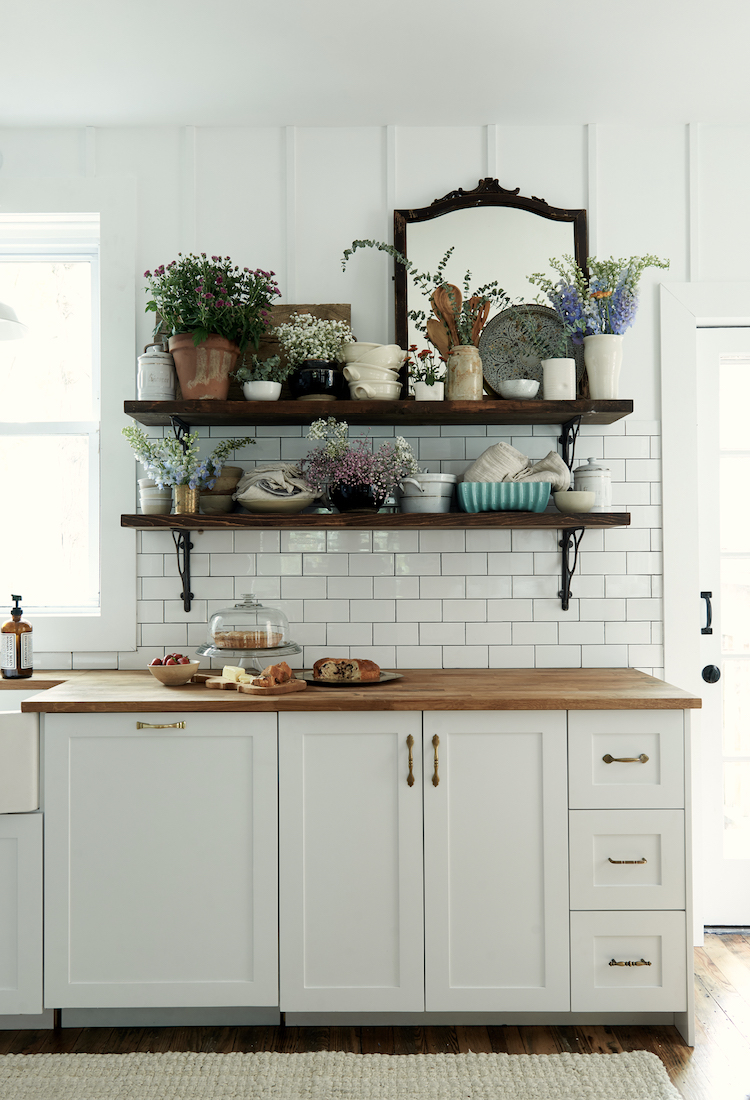 Farm sink, subway tile backsplash, and open shelving in a modern farmhouse kitchen by Leanne Ford. #restoredbythefords #leanneford #modernfarmhousekitchen #farmsink #modernrustic #interiordesign