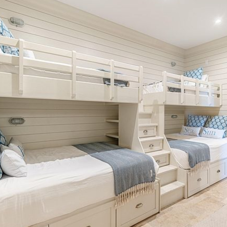 Bunk room with coastal style and blue accents in a luxurious Inlet Beach, FL home. #bunkrooms #coastalstyle