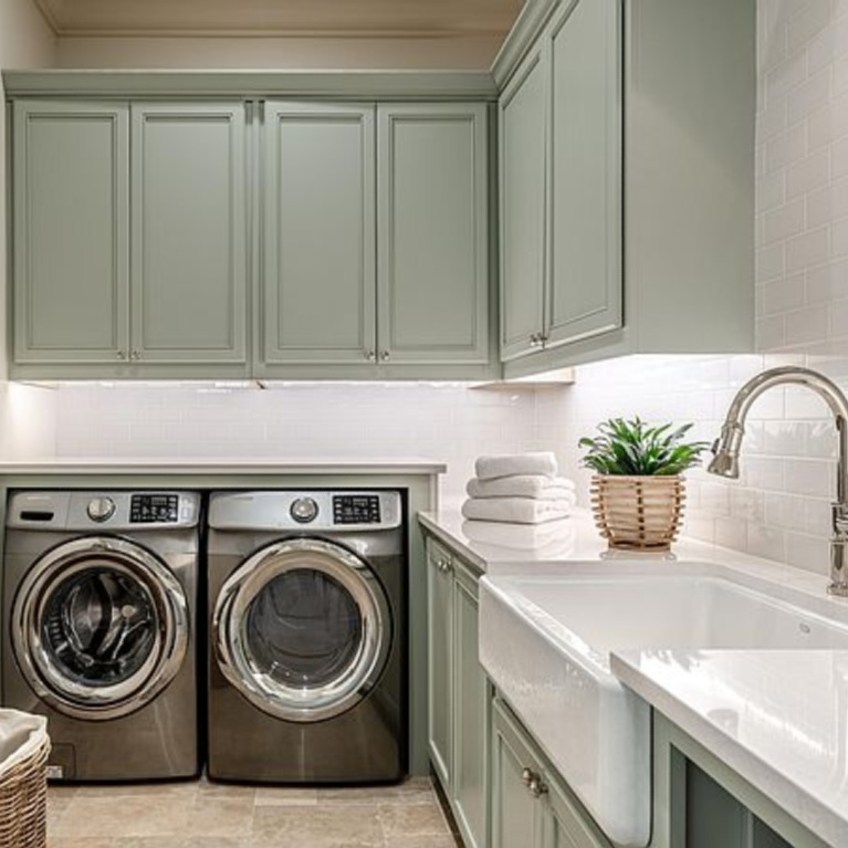 Laundry room with farm sink and tranquil color palette in a coastal home in Inlet Beach, FL. #laundryroom #coastalstyle