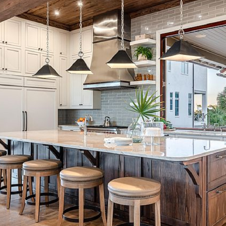 Charming coastal kitchen with wood ceiling and island in a luxurious Inlet Beach, FL home. #coastalkitchen #woodceiling