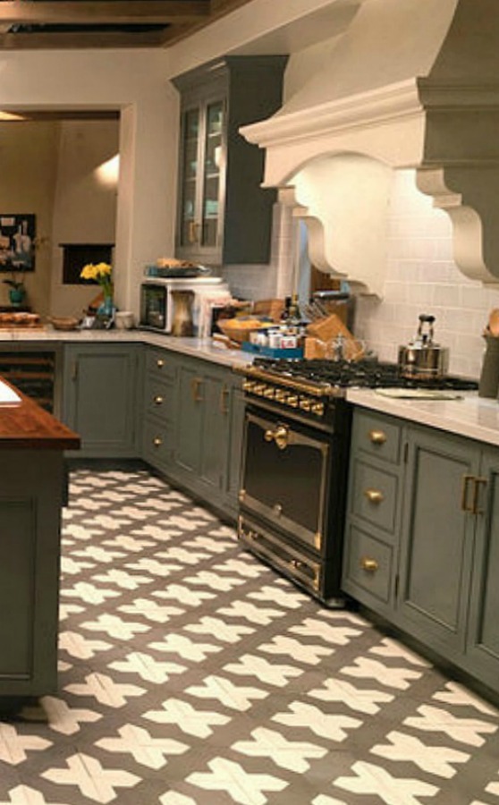 Robert and Sol's kitchen from Grace and Frankie has gorgeous Spanish cement tile, grey cabinets, and La Cornue stove with subway tile backsplash. #graceandfrankie #robertandsol #setdesign #kitchendesign #spanishtile #kitchenisland #lacornue