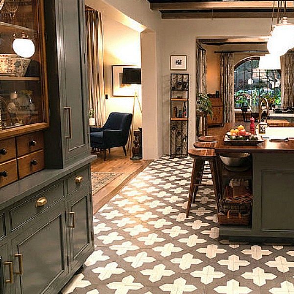 Robert and Sol's kitchen from Grace and Frankie has gorgeous Spanish cement tile, grey cabinets, and La Cornue stove with subway tile backsplash. #graceandfrankie #robertandsol #setdesign #kitchendesign #spanishtile #kitchenisland