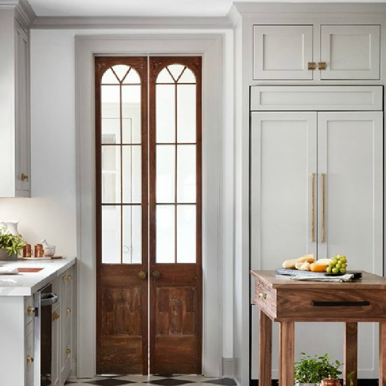 Light grey painted cabinets in a traditional Tudor cottage kitchen with wood stained double doors - Scrivano House (episode 4) on HGTV Fixer Upper with Joanna Gaines.