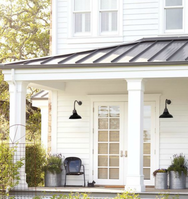 Beautiful white modern farmhouse porch and exterior with metal roof and dome shade barn style sconces from Rejuvenation. #modernfarmhouse #houseexterior #metalroof #barnlights