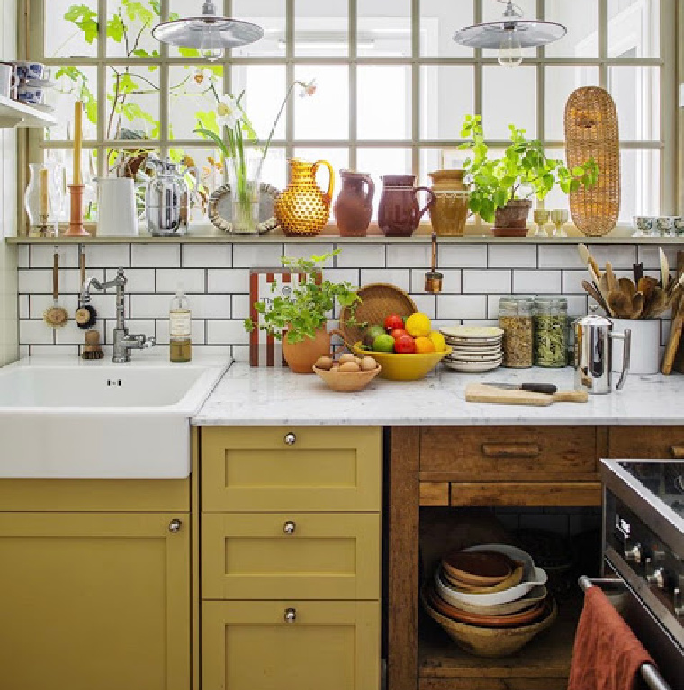 Warm yellow painted kitchen cabinets and subway baksplash in a cheerfully organic space - via designindulgence. #yellowabinets #kitchendesigns