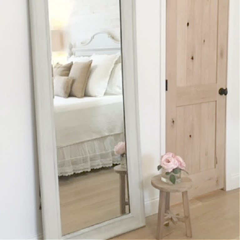 Serene airy bedroom with cottage style furniture and knotty alder doors as well as white oak hardwoods - Hello Lovely Studio.