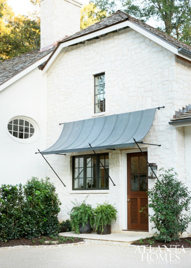 Beautiful white brick house exterior (Michael Ladisic) with awning and black window and trim. #housearchitecture #housedesign #whitebrick #houseexterior #blackandwhite