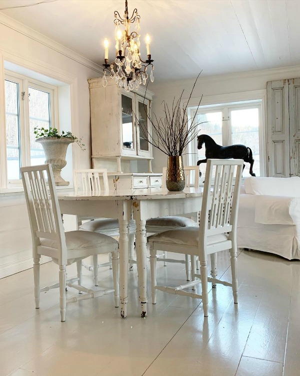Charming all white dining room with white painted floors and French Nordic decor by Cathrine Aust. #frenchnordic #diningroom #allwhitedecor #scandinaviandesign
