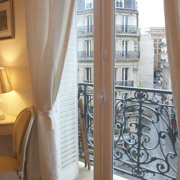 French Nordic decor in a Paris apartment with balcony and view of Hausmann style buildings - Hello Lovely Studio. #nordicfrench #parisapartment #frenchstyle #parisbalcony