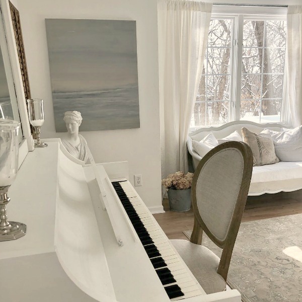 Hello Lovely's serene studio with white piano, French settee, and original painting. #hellolovelystudio #nordicfrenchstyle #serenedecor #whitepiano