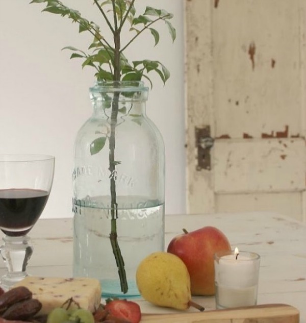 Serene still life with simple and spare vintage glass bottle as vase for a branch in a Nordic French studio by Hello Lovely. #stilllife #frenchnordic #nordicfrench #hellolovelystudio #serenedecor