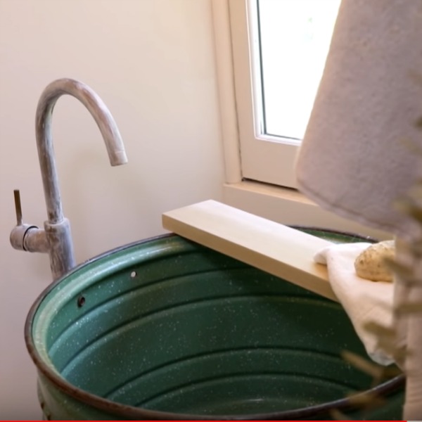 Vintage trough sink in a rustic luxe bathroom by Leanne Ford in a cottage renovated on Restored by the Fords. #restoredbythefords #leanneford #bathroomdesign #farmhousebathroom