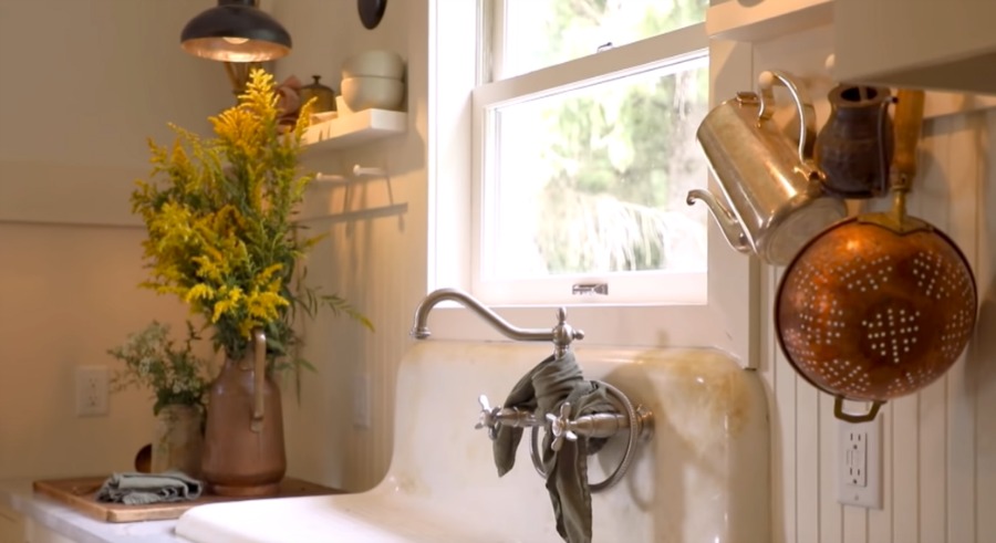 Vintage sink in original aged condition with Shaker style peg rack with farmhouse treasures in a rustic serene kitchen by Leanne Ford. #rusticdecor #kitchendesign #farmhousekitchen #farmsink #leanneford