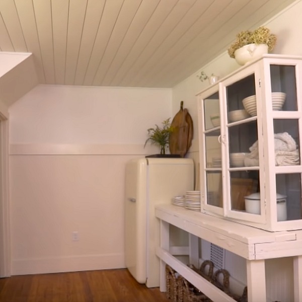 Smeg refrigerator and vintage cupboards in a rustic, laid back, cozy white cottage kitchen renovated by Leanne Ford. #leanneford #kitchendesign #smeg #vintagestyle