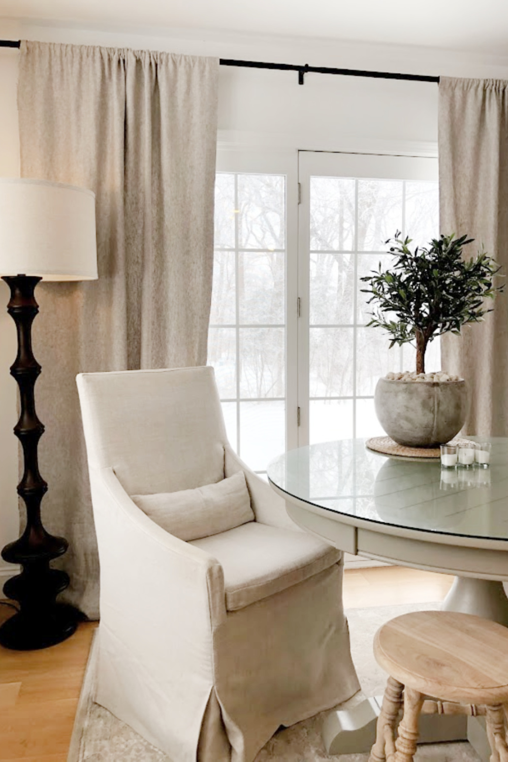 Belgian linen slope arm RH dining chair in breakfast nook with artificial olive tree in rustic pot - Hello Lovely Studio.