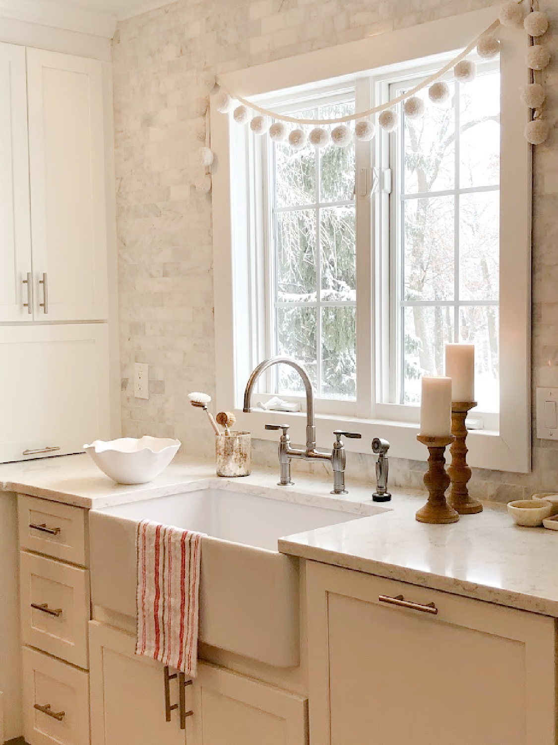 Serene European country farmhouse kitchen with farm sink, Viatera Minuet counters, and marble subway tile backsplash - Hello Lovely Studio.